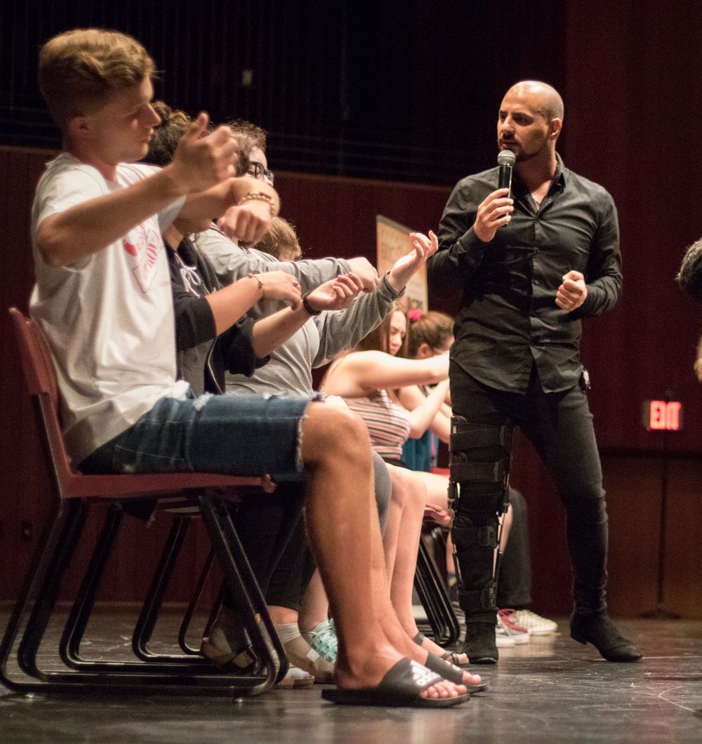 Student volunteers on stage during Eric Mina's show