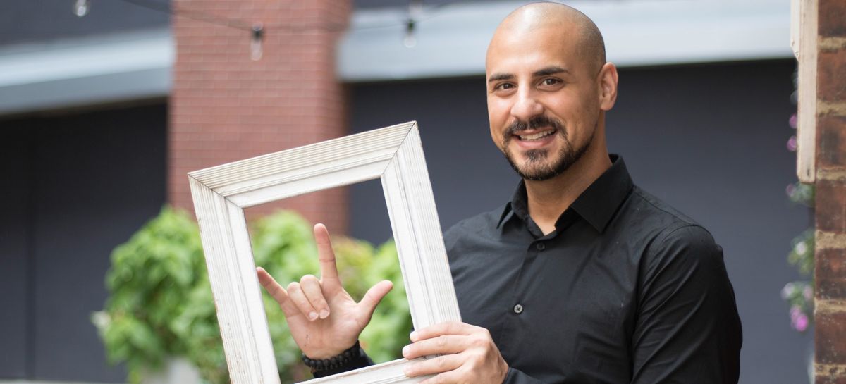 Eric Mina holding a picture frame and smiling