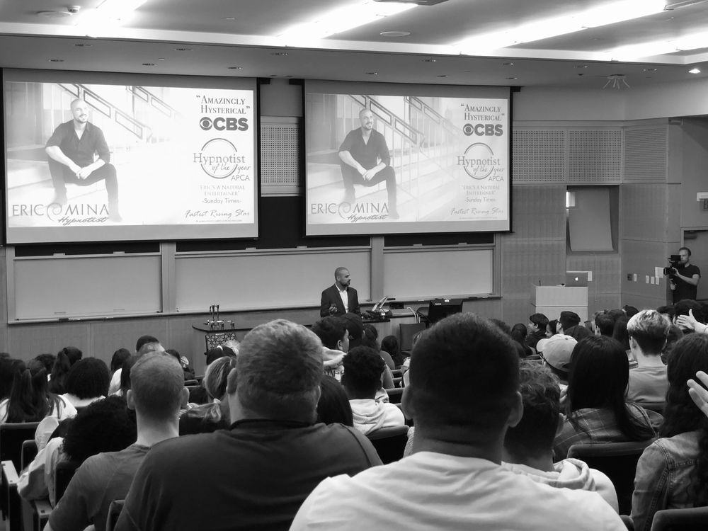 Eric Mina speaking to a large audience