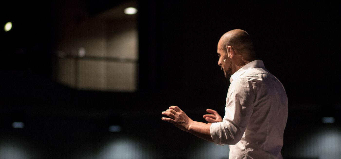 Eric Mina delivering a keynote to a large audience